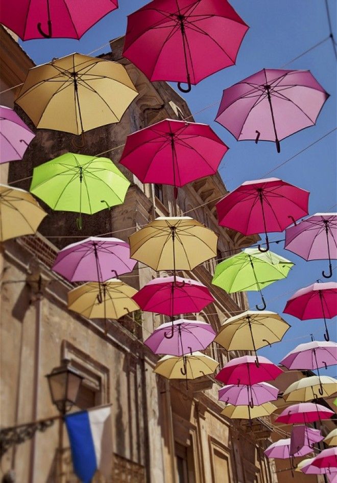 На одном из бульваров города Агуеды в Португалии расположилась яркая и неповторимая инсталляция созданная фирмой Sextafeira которая называется Парящие зонтики