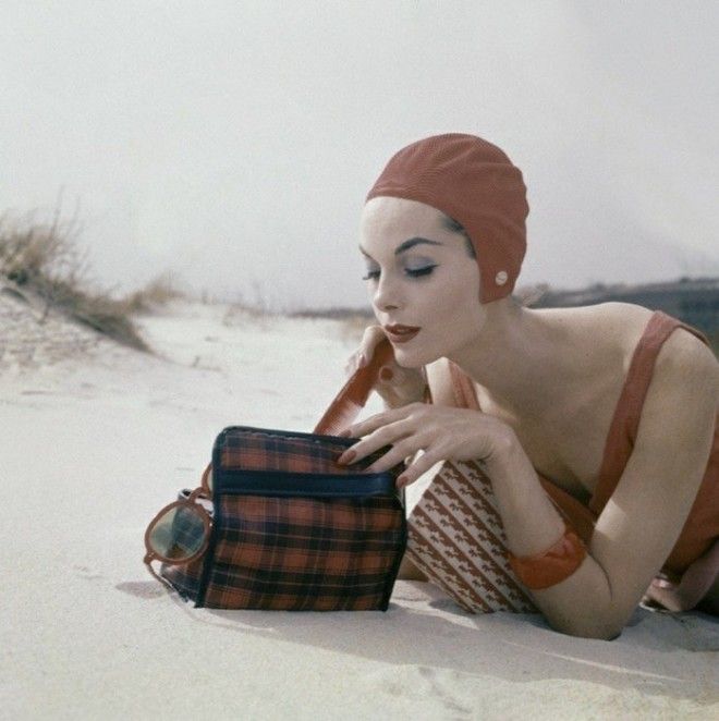 Девушка достающая из сумки расческу на пляже 1950е годы