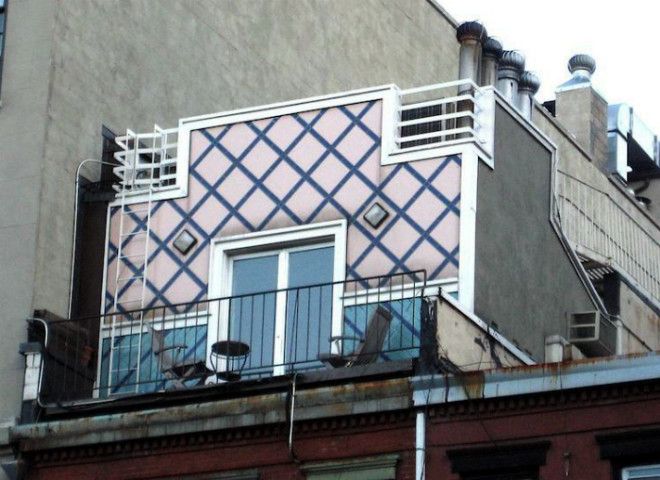 Небольшой розовый домик на крыше многоэтажки