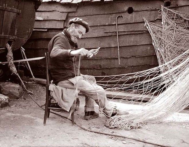 Мужчина чинит рыбацкую сеть Нормандия