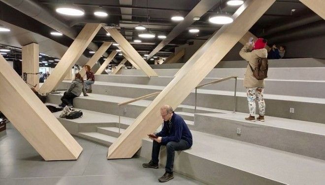 Большой амфитеатр с деревянными опорами служит местом для чтения общения и просто отдыха Центральная библиотека Oodi Хельсинки Фото strelkamagcom